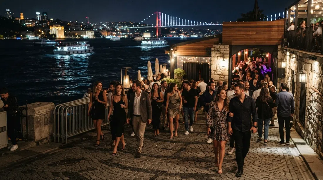 Sortie de noche en Kuruçeşme, luces de club al aire libre reflejándose en el agua con una multitud arreglada llegando